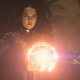 Alina, wearing an ornate blue dress, summons a small sun in front of her.